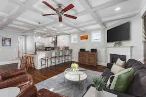 Big cozy living room with a gas fireplace and a Smart TV with all the streaming apps. Open floor plan leads to the kitchen & dining areas.