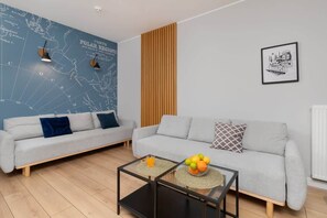 A cozy lounge area with a blue accent wall, a light gray sofa, and contemporary decor elements for a welcoming ambiance.
