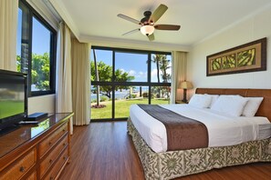Relax in this bright master bedroom with tropical accents, ocean-facing windows, and a king-sized bed for ultimate comfort during your vacation.