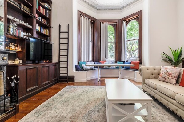 Enjoy a peaceful meal sitting at the dining table that wraps around the tall arched windows. Light, warmth and leafy street views provide the perfect setting. 
