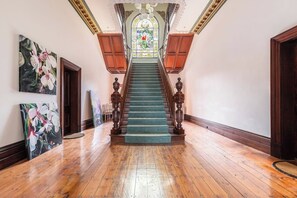 The entrance to the apartment is nothing short of grand. The decorative stained glass windows, classic wooden staircase and elaborate ceilings are a timeless beauty. 
