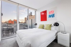 The primary bedroom offers a queen bed, direct balcony access and sweeping glass doors so you can enjoy winding down amongst twinkling city views.