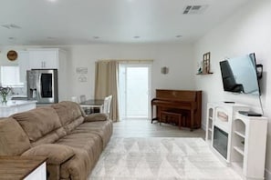 Living room with sliding glass doors to backyard for ample light and breeze.
