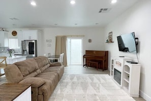 Living room with sliding glass doors to backyard for ample light and breeze.