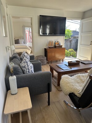 Large TV is wall mounted, gate leg table beneath opens for dining, or puzzles.