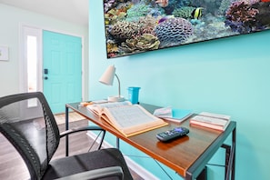 The living room's built in work station features a comfy chair and low profile