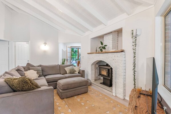 Relax by the cozy fire beneath a grand, rustic mantle — the perfect winter retreat spot.