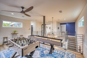 Game room with shuffleboard, foosball, a TV, and balcony access.