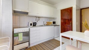 Kitchen includes an oven, stove, mini fridge, electric kettle, microwave and capsule coffee machine