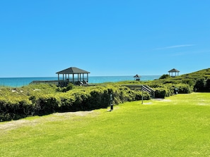 Recreational area with picnic tables, outdoor showers, and charaoal grills.