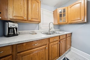 The kitchen is well-stocked, with newer cabinets and appliances.