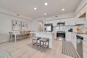 The kitchen merges effortlessly with the dining area, creating a shared space for cooking and dining. Contemporary amenities and chic decor provide an ideal backdrop for culinary exploration and savored meals with family and friends.