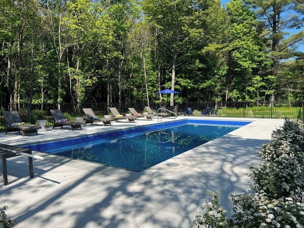 Swimming pool with lounge chairs in the backyard