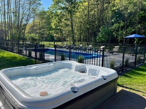 Hot tub leading to swimming pool in the back yard