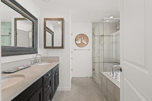 Walk-in shower with glass enclosure in ensuite bathroom