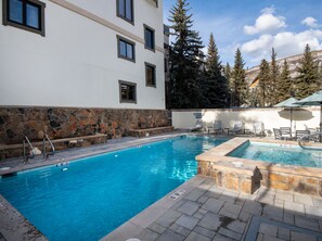 Shared Pool and Hot Tub Area - Outdoor Fireplace with Dining Tables and Sun Loungers