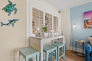 Dining space seats four with two chairs and a roomy bench—great for family meals. The condo includes all cookware and dinnerware, making it simple to cook and enjoy quality time together during your beach getaway.