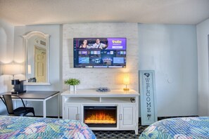 Unwind in a cozy oceanfront bedroom featuring two plush queen beds, a 50” Smart TV, a warm fireplace, a spacious closet, and ample clothing storage. Relax in comfort with modern amenities, perfect for a restful Myrtle Beach stay!
