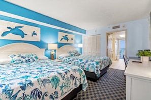 Relax in a beach-inspired bedroom featuring two plush queen beds, a 50” Smart TV, a cozy fireplace, and ample clothing storage. Enjoy comfort and convenience in a beautifully decorated space, perfect for your Myrtle Beach getaway!