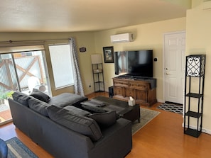Living room. 65 inch TV with soundbar and sub. Bluetooth speaker.