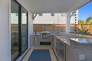 Homes well-equipped outdoor kitchen and bar.