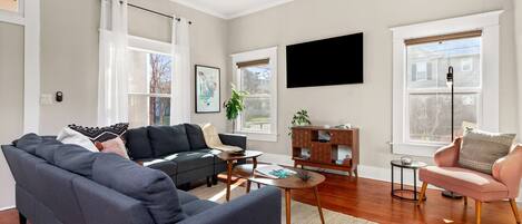 Living room serenity: where the glow of the TV meets the comfort of the sofa, framed by the warmth of natural light