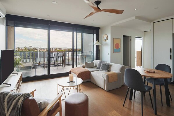 The light-filled living space includes a sofa and chaise where you can kick back with some TV after a day of work or sightseeing. 
