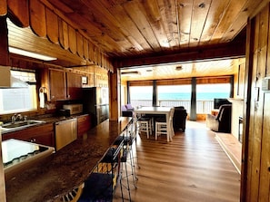 Open-concept kitchen, dining, and living area with panoramic ocean views