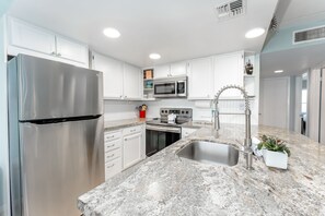 Our island kitchen is ideally equipped for family-style meal prep with it's ample counter space and appliances.