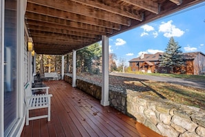 Bottom level porch with a porch swing and seats