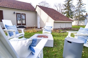 Patio in the backyard with 4 adirondack chair and fire pit