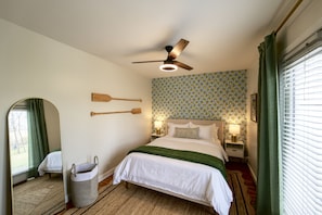 Bedroom with queen bed, with plush beddings, ceiling fan, and windows