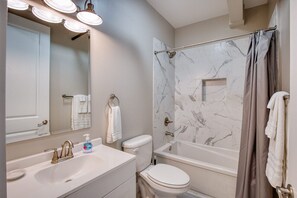 Indulge in a relaxing soak after a day at Biloxi Beach or Casinos, complemented by a sleek vanity with a softly lit mirror—ideal for unwinding in pure comfort.