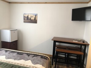 Table area, smart tv, and mini refrigerator. 