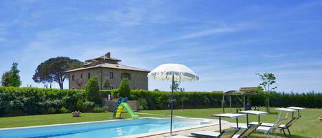 The property surrounded by greenery and the beautiful shared pool.