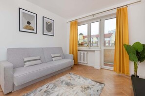 Bright living room with a gray sofa, vibrant yellow curtains, and a soft rug, giving a cheerful and modern vibe.
