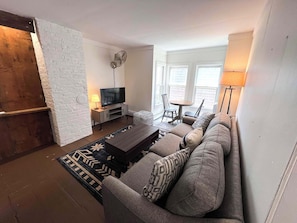 Living room with smart TV, a coffee/laptop table, and a little dining alcove.