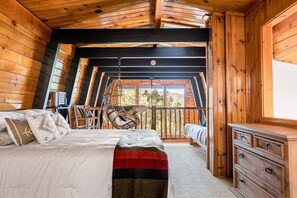 The second bedroom features a boho hanging chair, double size futon, queen size bed and a single bed for multiple sleeping options.