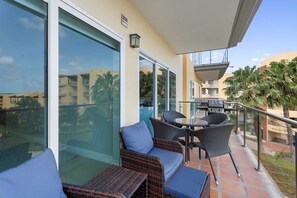 The balcony with a 4-seat table plus 2 chairs with ottomans neatly tucked underneath