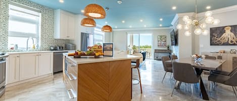 Open concept kitchen, living and dining room w/ beautiful ocean view from walk-out patio