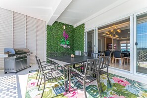 Beautiful, spacious patio overlooking the pool w/ BBQ, outdoor table & greenery wall featuring neon sign!