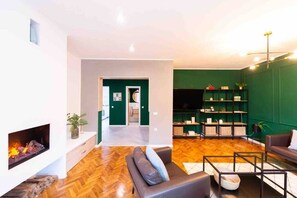 Living room with large TV set and a cosy fireplace