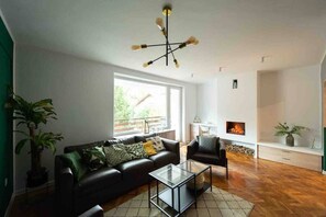 Living room featuring a large window with seating, as well as a designated working space