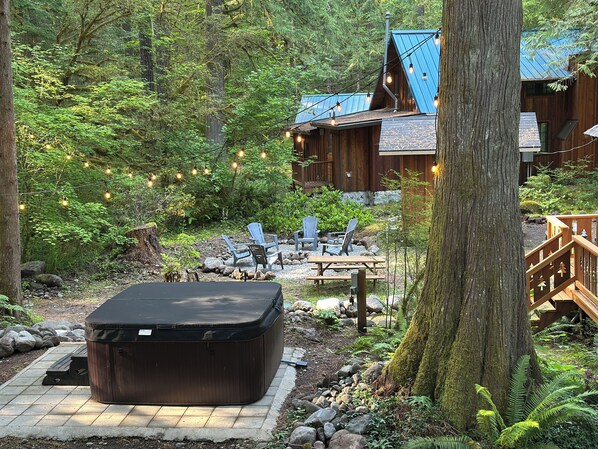 Your outdoor oasis awaits, complete with a picnic table, fire pit, hot tub & BBQ