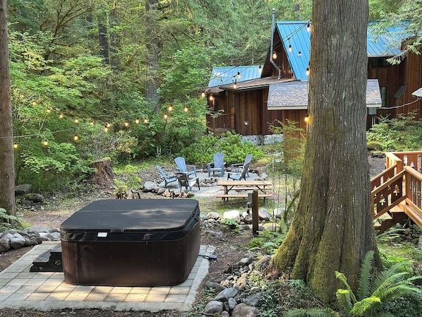 Your outdoor oasis awaits, complete with a picnic table, fire pit, hot tub & BBQ