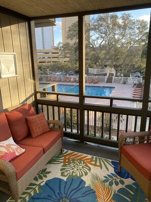 Private screened balcony with pool view & comfy new furniture