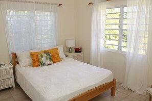 Step into a snug bedroom with a queen bed and tranquil views of the backyard.