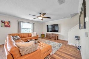The downstairs living room has plenty of seating and a large TV, perfect for relaxing. 