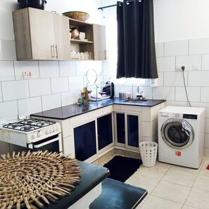 A well equipped kitchen with washing machine  as well 