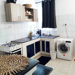 A well equipped kitchen with washing machine as well